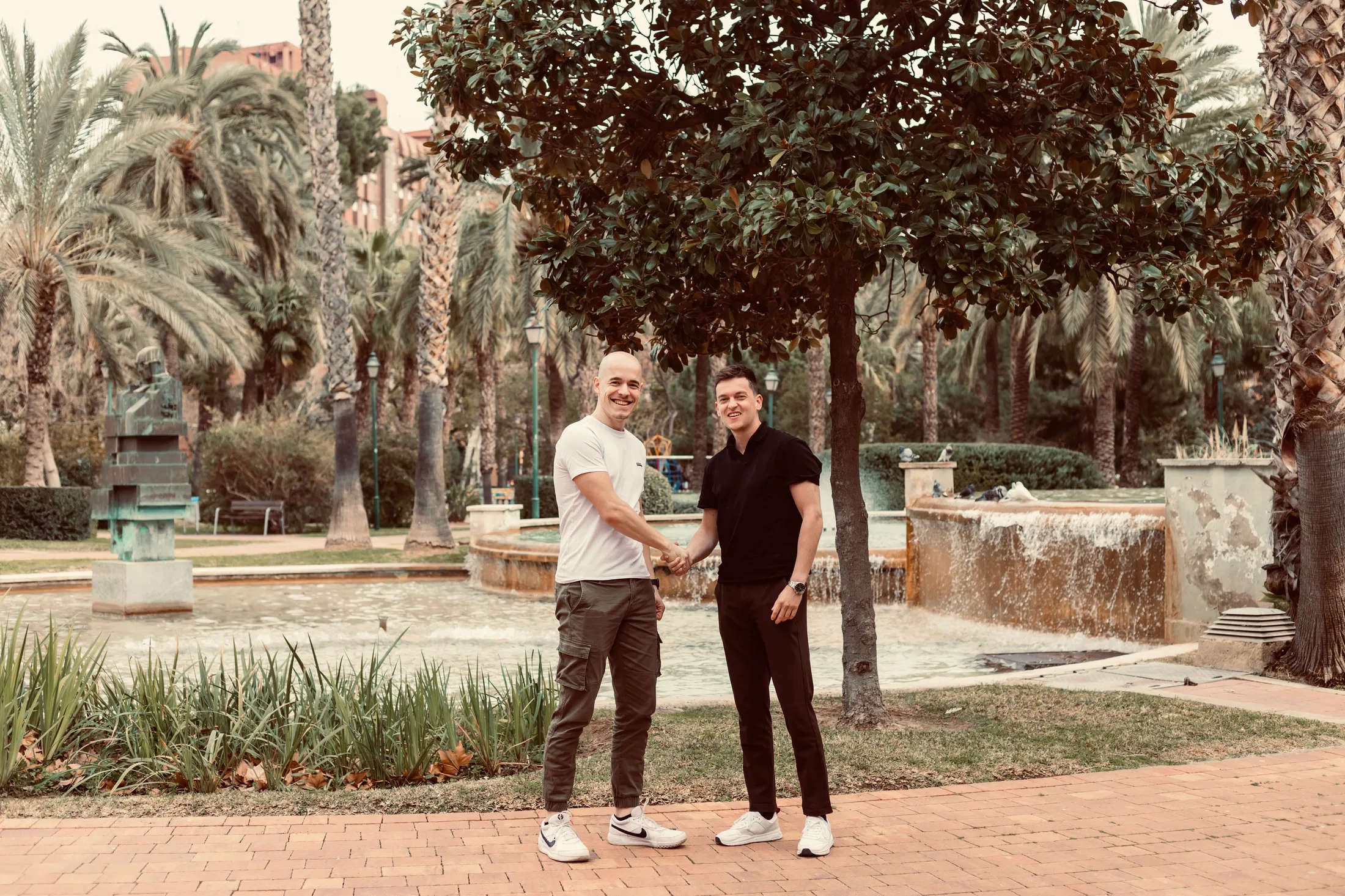 Zwei Freunde, die sich in einem Park in Valencia die Hand geben