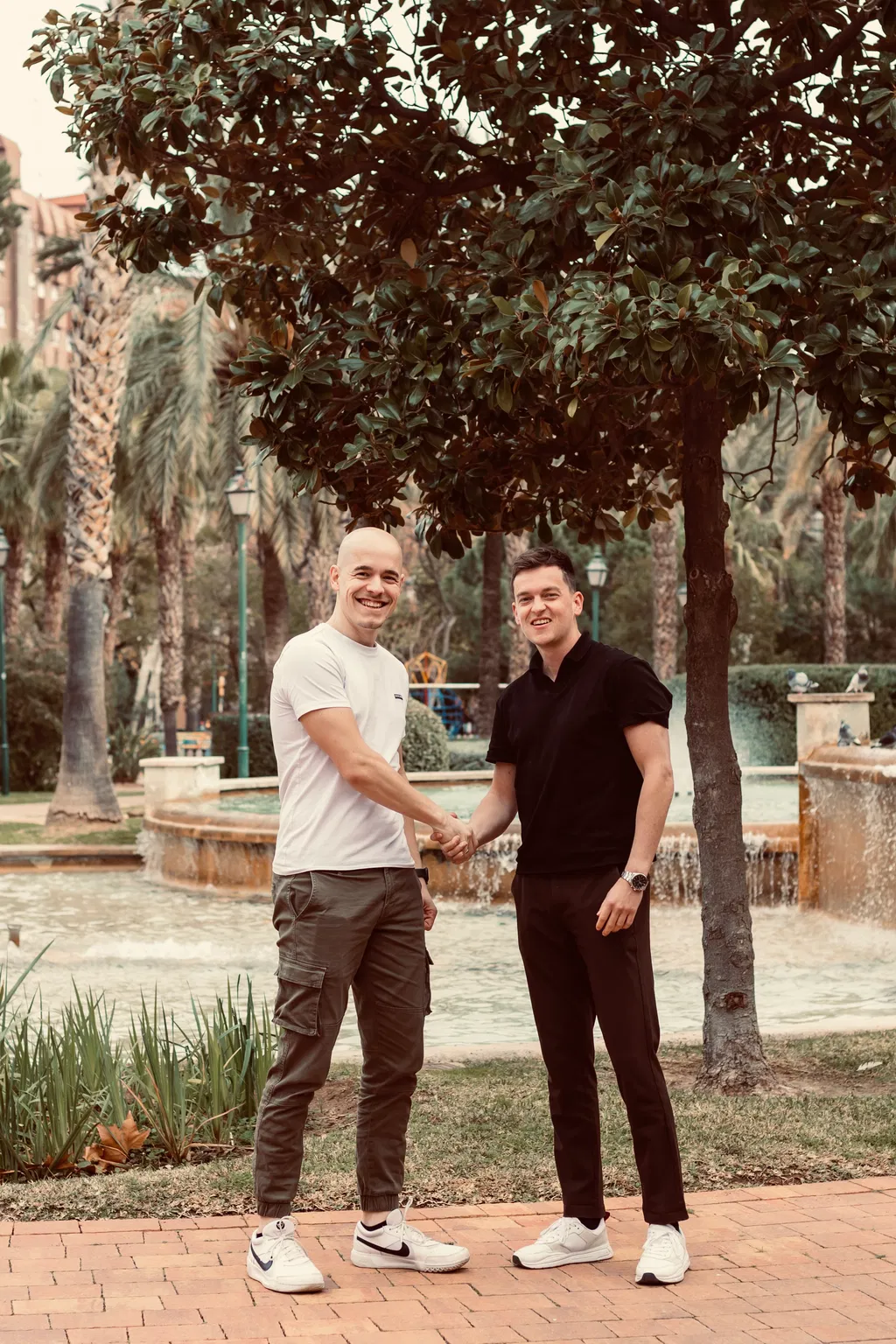 Twee vrienden die handen schudden in een park in Valencia